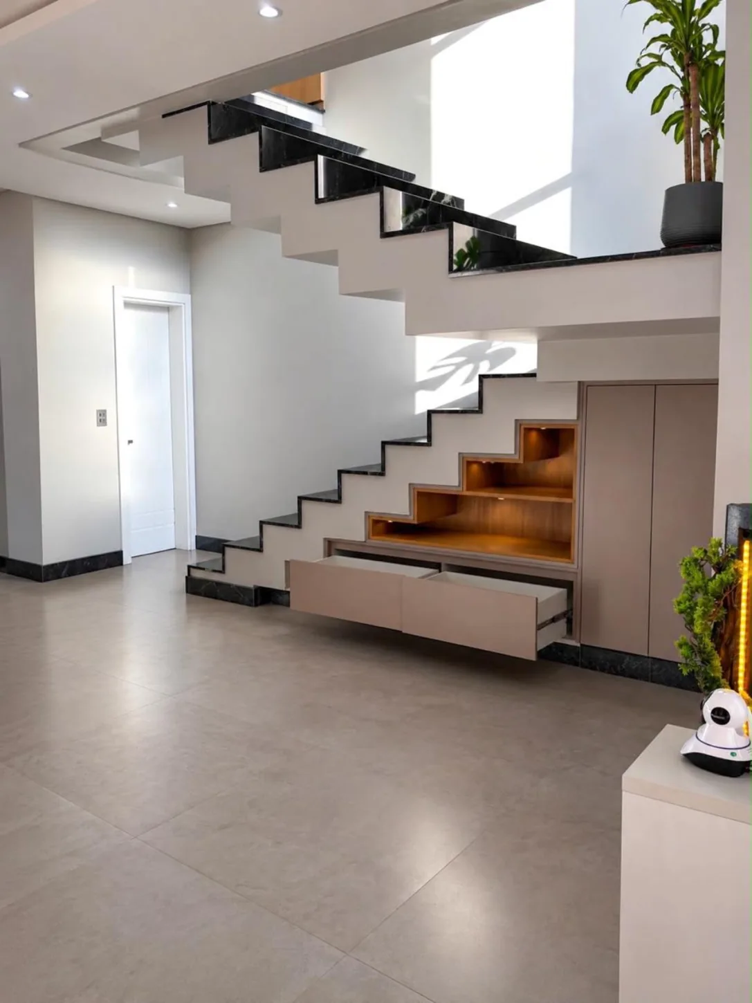 Marcenaria sob escada com gavetões e iluminação